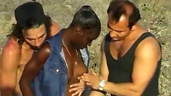 African-American Woman Participates In Threesome With Two Caucasian Men By The Ocean